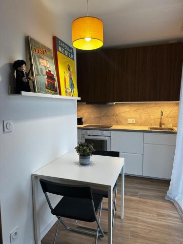 une cuisine avec une table blanche et des chaises dans l'établissement Le Chintre, à Bazouges