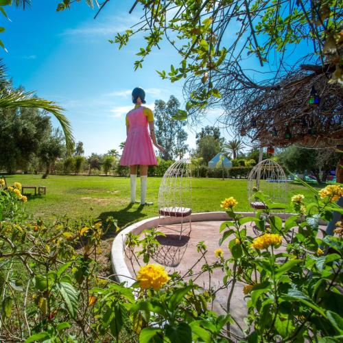 a woman in a pink dress standing in a park at Les Jardins D'issil in Marrakech