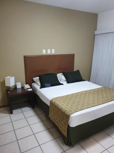 a hotel room with a bed and a nightstand with a bed sidx sidx sidx at Flat Metropoles Ilha do Leite by Easy Home in Recife