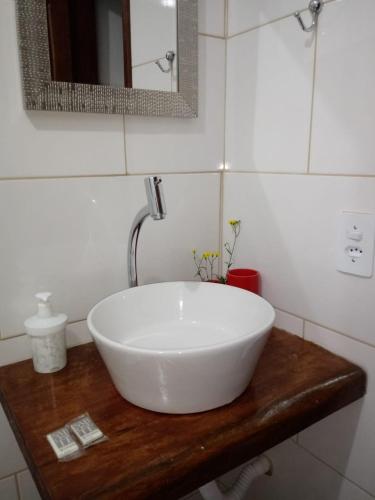 a white sink on a wooden counter in a bathroom at A Canastra Casa e Chalés in São Roque de Minas