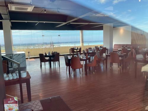a dining room with tables and chairs in a restaurant at Grand Residence Negombo By Ocean Breeze in Negombo