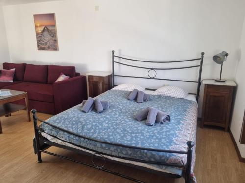 a bedroom with a bed and a couch at Bella Fosano by Fewotessin in Gambarogno