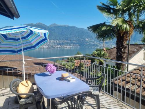 a table and chairs on a balcony with a view of the water at Bella Fosano by Fewotessin in Gambarogno