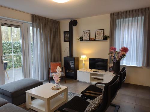 a living room with a couch and a tv at 'APPARTEMENT RANDDUIN' Bed by the Sea in Dishoek