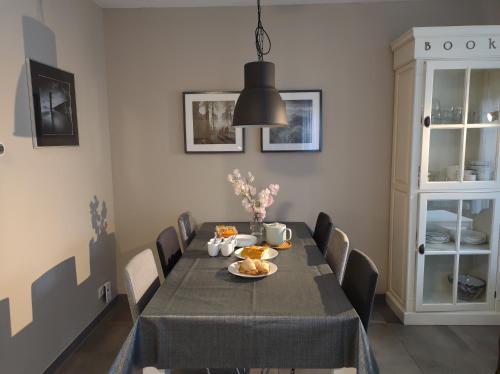a dining room with a table with chairs and a black table cloth at 'APPARTEMENT RANDDUIN' Bed by the Sea in Dishoek