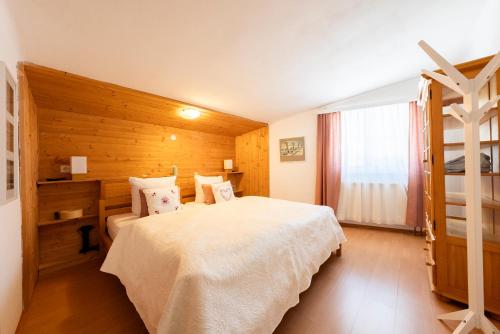 a bedroom with a white bed and a wooden wall at Haus Frey in Altaussee