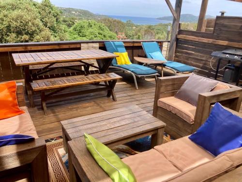 une terrasse avec des tables et des chaises en bois et un grill dans l'établissement Appartement Cemiliana, à Bonifacio