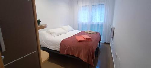 a small bedroom with a bed with a red blanket at Alojamiento Evelyne Cal Paleta Noves de Segre in Novés de Segre