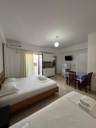 a hotel room with two beds and a dining table at Guesthouse Mance in Ksamil