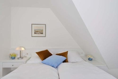 a white couch with two pillows on it at Kairem Ingiwai 22c in Keitum