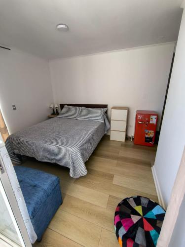 1 Schlafzimmer mit 2 Betten und Holzboden in der Unterkunft Depto Estudio con hermosa vista al mar in Valparaíso