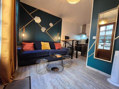 un salon avec un canapé bleu et une table dans l'établissement studi'home, à Rouen