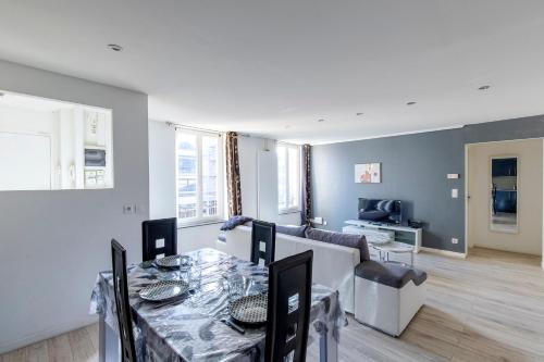 un salon avec une table et un canapé dans l'établissement Le Lagon Parking Un Séjour à Part, à Longeville-lès-Metz