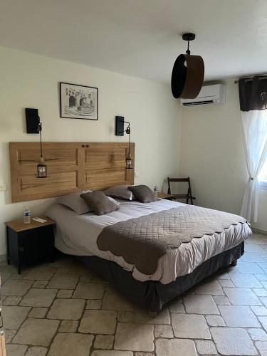 une chambre avec un grand lit dans une pièce dans l'établissement Maison d'hôte en Provence avec petit déjeuner, à Mollégès