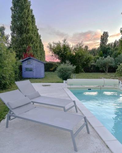 une paire de chaises et une piscine dans l'établissement Maison d'hôte en Provence avec petit déjeuner, à Mollégès