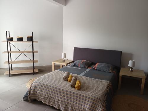 een slaapkamer met een bed met twee paar schoenen erop bij Appartement st leu Vill'Alizoé in Entre-Deux