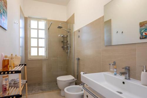 a bathroom with a toilet and a sink and a shower at Breathtaking View - IsulaTravel in Marina di Modica