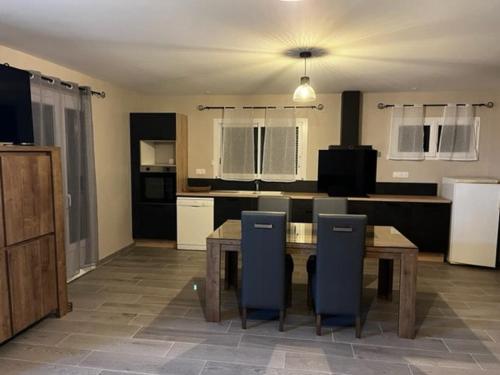 une cuisine avec une table et des chaises dans une pièce dans l'établissement Charming new independent apartment in a quiet area, à Saint-Pardoux-la-Rivière