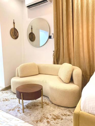 a living room with a couch and a round mirror at Cribside - Lekki Phase 1, Lagos in Ilado