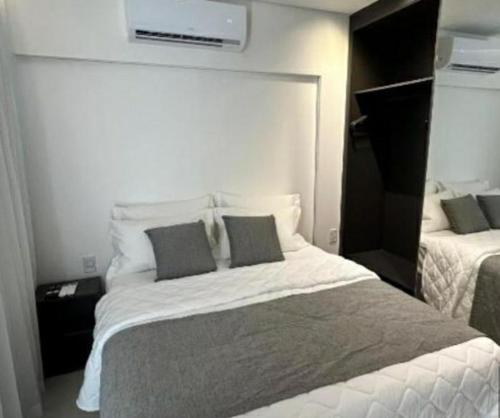 una camera da letto con un grande letto bianco con due cuscini di Porto Alto Resort - GAV a Porto De Galinhas