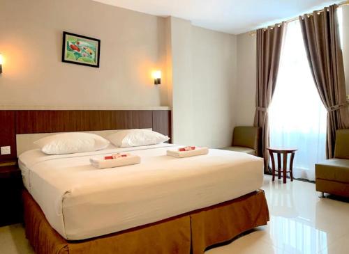a bedroom with a large bed with two pillows on it at Hotel Holitel in Parit