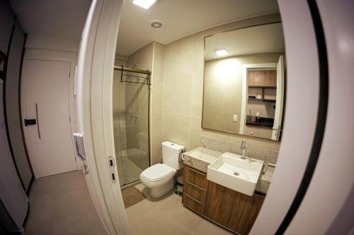 a bathroom with a toilet and a sink and a mirror at Studio completo Beach Class Salvador - Ondina - Circuito Carnaval in Salvador