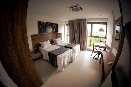 a hotel room with two beds and a window at Studio completo Beach Class Salvador - Ondina - Circuito Carnaval in Salvador