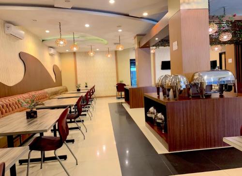 a restaurant with tables and chairs and a bar at Hotel Holitel in Parit
