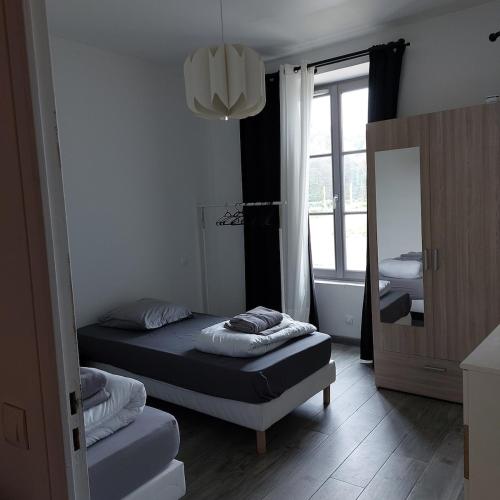 une petite chambre avec un lit et un miroir dans l'établissement Ground floor apartment in farmhouse, à Villiers-le-Bâcle