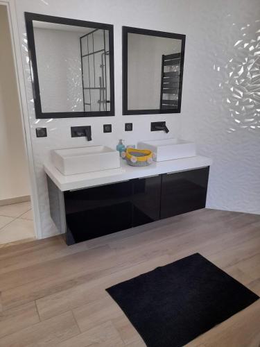 une salle de bain avec un lavabo blanc et deux miroirs dans l'établissement villa en corse, à Biguglia