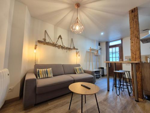 un soggiorno con un divano e un tavolo di studi'home a Rouen