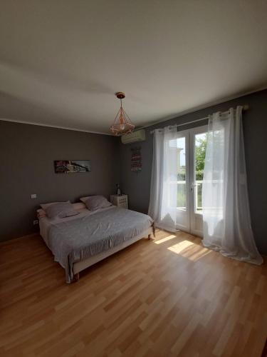 une chambre avec un lit et une grande fenêtre dans l'établissement villa en corse, à Biguglia