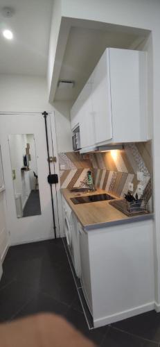 une cuisine avec des armoires blanches et un évier dans l'établissement Studio hyper centre Nice, à Nice