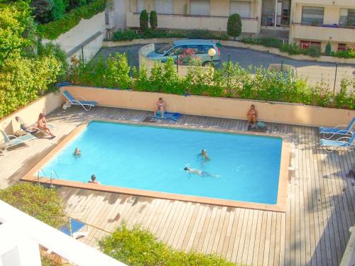 un groupe de personnes nageant dans une piscine dans l'établissement Apartment Cannes Felibriges, à Cannes