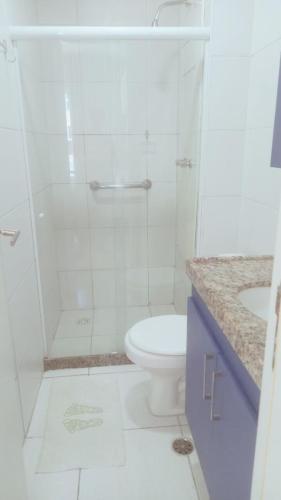 ein weißes Badezimmer mit Dusche und Toilette in der Unterkunft Muro Alto Condomínio Clube - Porto de Galinhas in Porto De Galinhas