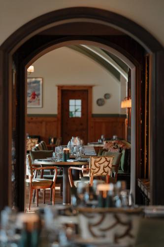 a dining room with tables and chairs and a mirror at Hotel GRACE LA MARGNA ST MORITZ in St. Moritz