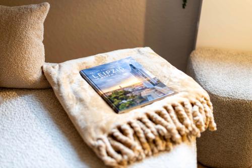 a book sitting on top of a couch at Apartment Suite von Spears - Edles Design mit Balkon und kostenloser Tiefgarage im Neuseenland in Markkleeberg