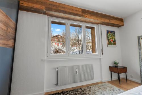 a bedroom with a window and a radiator at Appartement fraîchement rénové à Crans-Montana, vue imprenable in Crans-Montana
