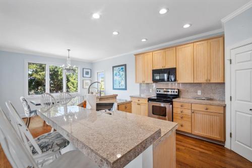 a kitchen with a marble counter top and wooden cabinets at Beach Access - Golf Cart Included - Views of the Marsh and Harbor River - Sleeps 10 in Harbor Island