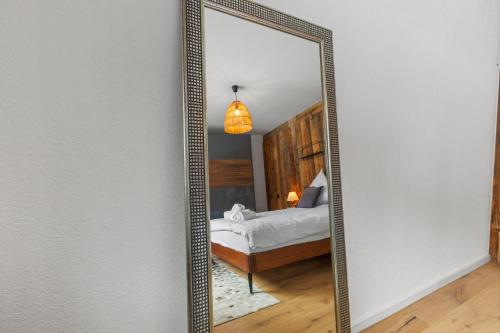 a large mirror in a room with a bed at Appartement fraîchement rénové à Crans-Montana, vue imprenable in Crans-Montana