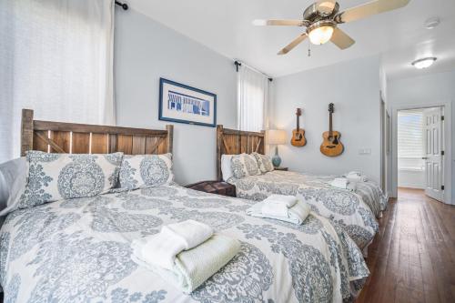 a bedroom with two beds and a ceiling fan at Beach Access - Golf Cart Included - Views of the Marsh and Harbor River - Sleeps 10 in Harbor Island