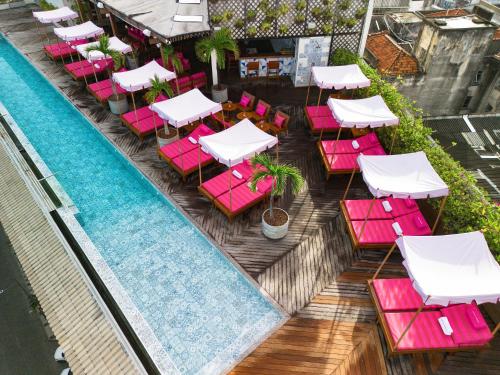 サルバドールにあるFera Palace Hotelのピンクと白のテーブルと椅子が備わるプールの景色を望めます。