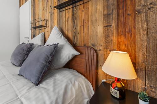a bed with pillows and a lamp on a table at Appartement fraîchement rénové à Crans-Montana, vue imprenable in Crans-Montana