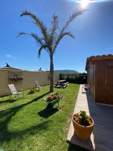 a garden with a palm tree and a table and chairs at Casas Guemon in Zahora