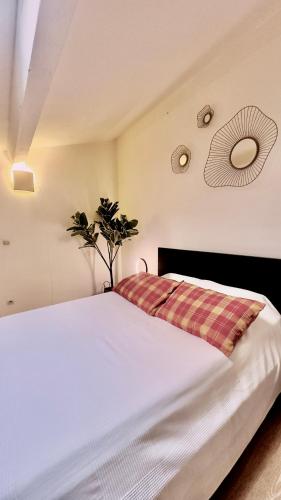 - une chambre avec un lit blanc et une couverture tressée dans l'établissement 2 Bedroom Duplex Center, Patio, à Montpellier