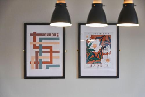 two framed posters hanging on a wall with lights at Ropewalks Retreat III - Sleeping 8 Guests with Parking in Liverpool