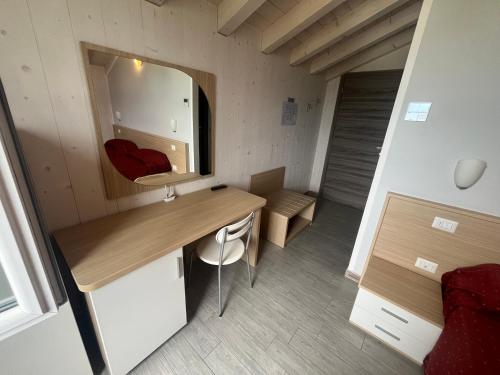 a small room with a desk and a mirror at Rifugio Punta Maestra in Pila