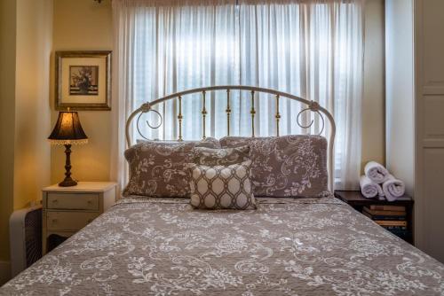 ein Schlafzimmer mit einem großen Bett mit Kissen und einem Fenster in der Unterkunft Poe House in Paso Robles