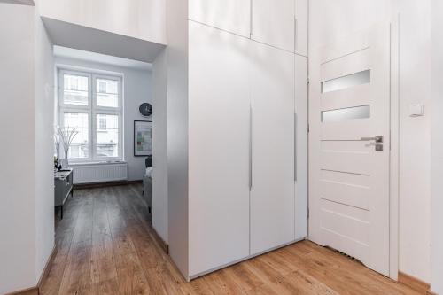 a white closet in a room with wood floors at Piwna Number 1 in Gdańsk