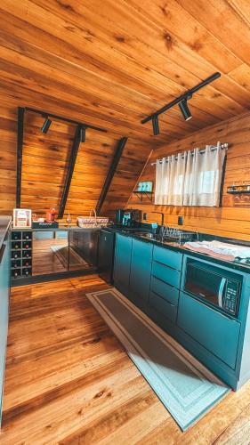 a kitchen with wooden floors and a wooden ceiling at Chalé vale das cachoeiras in Barracão
